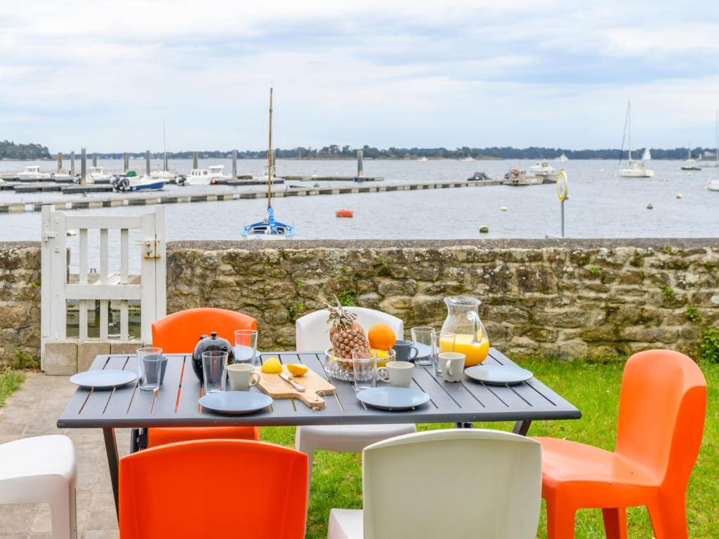 un tavolo e sedie con vista sull'acqua di Holiday Home Maison du Port by Interhome a Locmariaquer