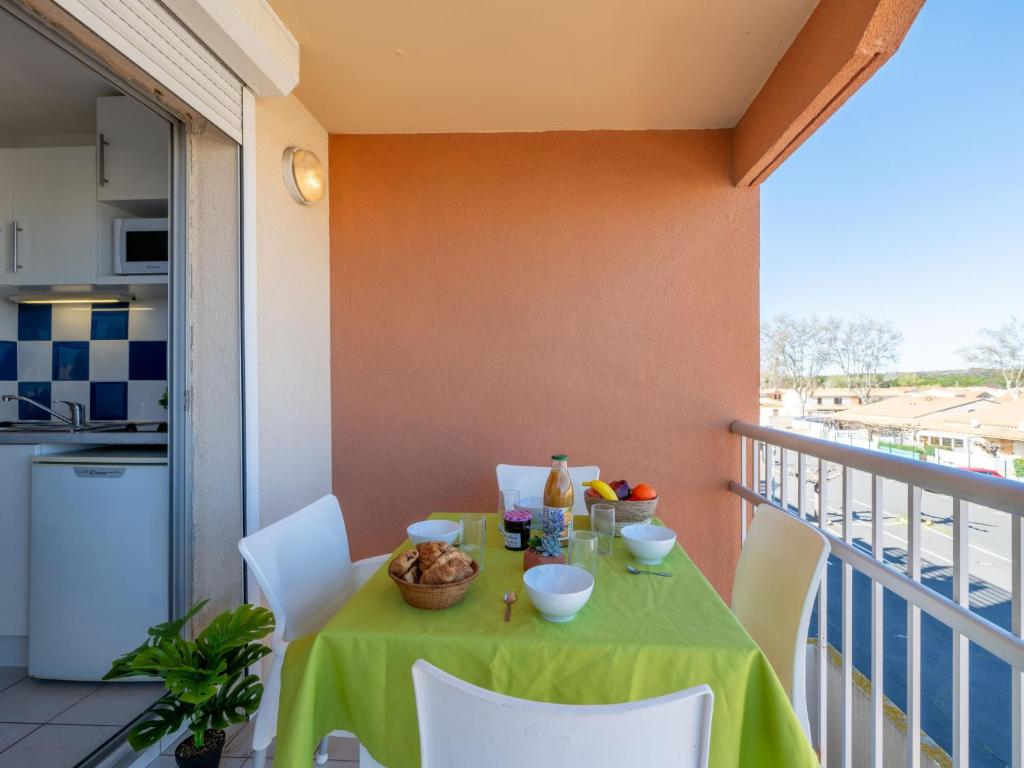 une table avec un tissu de table vert sur un balcon dans l'établissement Apartment Primavera-3 by Interhome, au Cap d'Agde