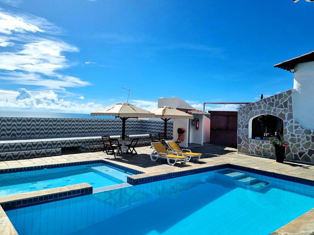 a swimming pool with a view of the ocean at Santorini Praia Hotel in Natal