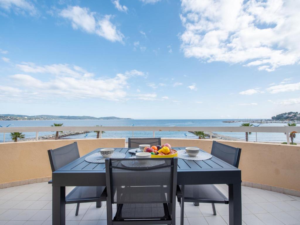 une table et des chaises sur un balcon avec vue sur l'océan dans l'établissement Apartment Le Palazzo del Mar-13 by Interhome, à Cavalaire-sur-Mer