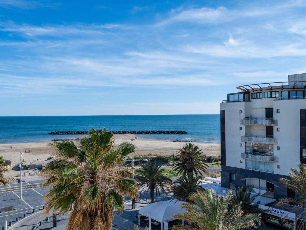 - une vue sur la plage et un bâtiment dans l'établissement Apartment Le Sunset-Cap Sud-24 by Interhome, au Cap d'Agde
