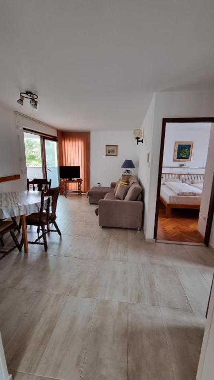 uma sala de estar com um sofá e uma mesa em Apartments Katja em Mali Lošinj