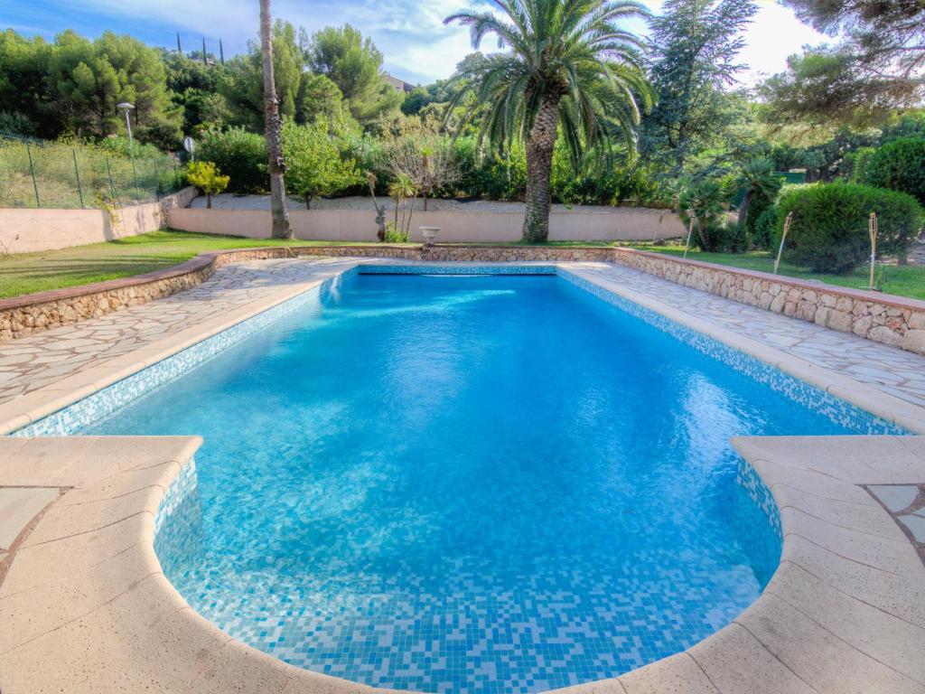 een zwembad met blauw water in een tuin bij Villa Cap Roux by Interhome in Agay - Saint Raphael