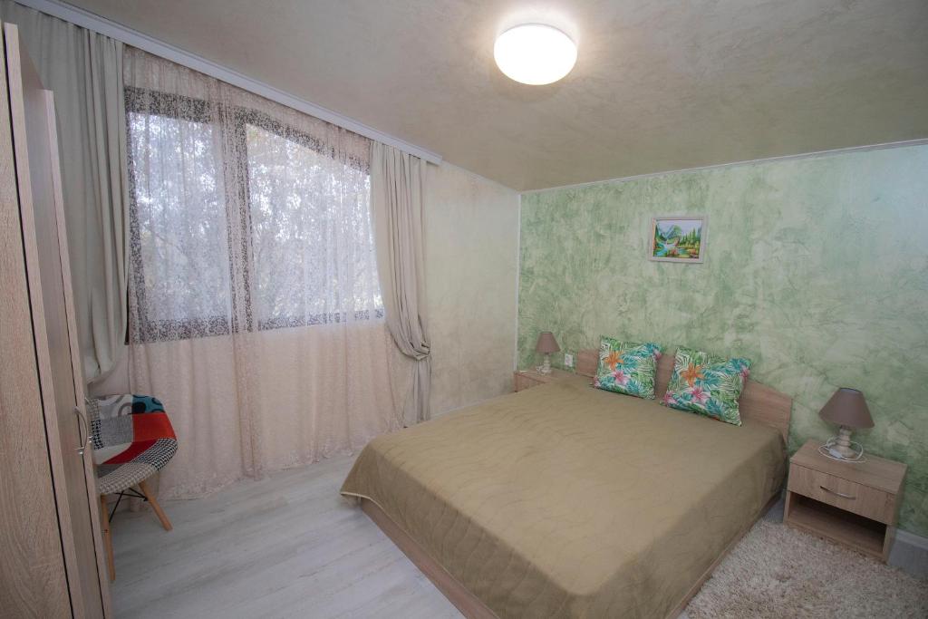 a small bedroom with a bed and a window at Kozareva Guest House 2 Козаревата Къща За Гости 2 in Dobrogled