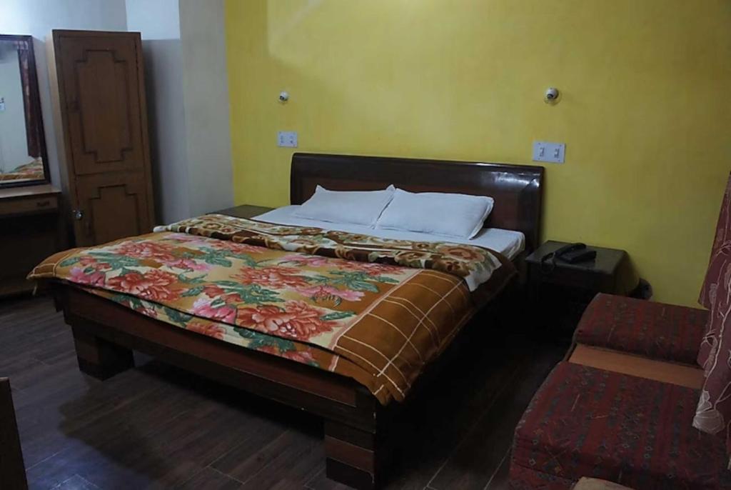 a bedroom with a large bed with a bedspread on it at Sanskar Sadan Home Stay Varanasi in Varanasi
