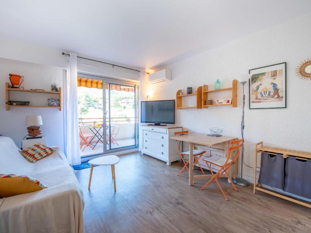 un salon avec une table et un bureau avec une télévision dans l'établissement Apartment Sémaphore-5 by Interhome, à Cavalaire-sur-Mer