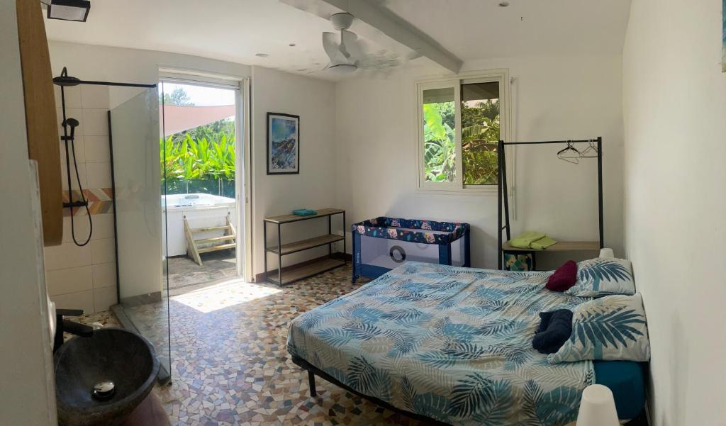 Schlafzimmer mit einem Bett, einem Spiegel und einem Fenster in der Unterkunft Studio 42 in Petit-Bourg