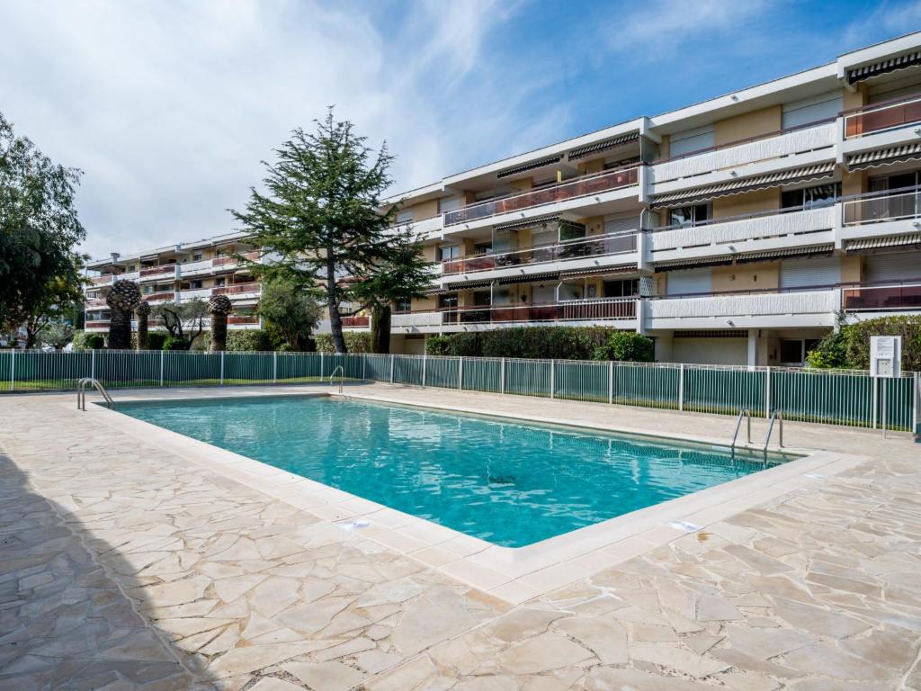 a swimming pool in front of a apartment building at Apartment Les cyclades by Interhome in Antibes