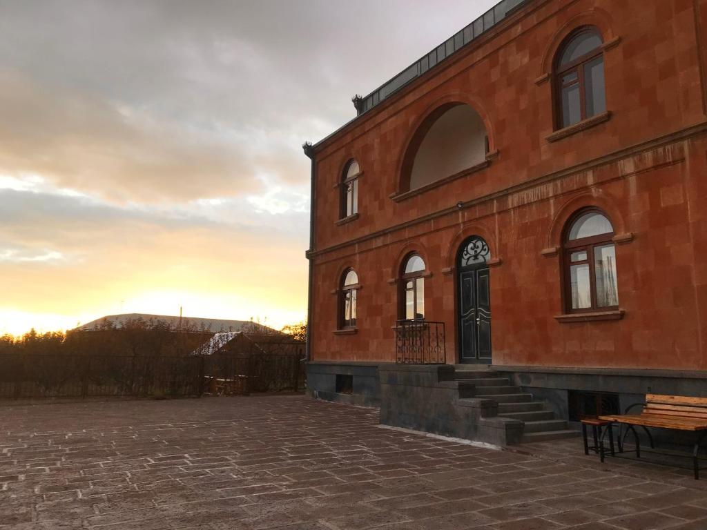 a brick building with a bench in front of it at Gyumrva Tun in Gyumri