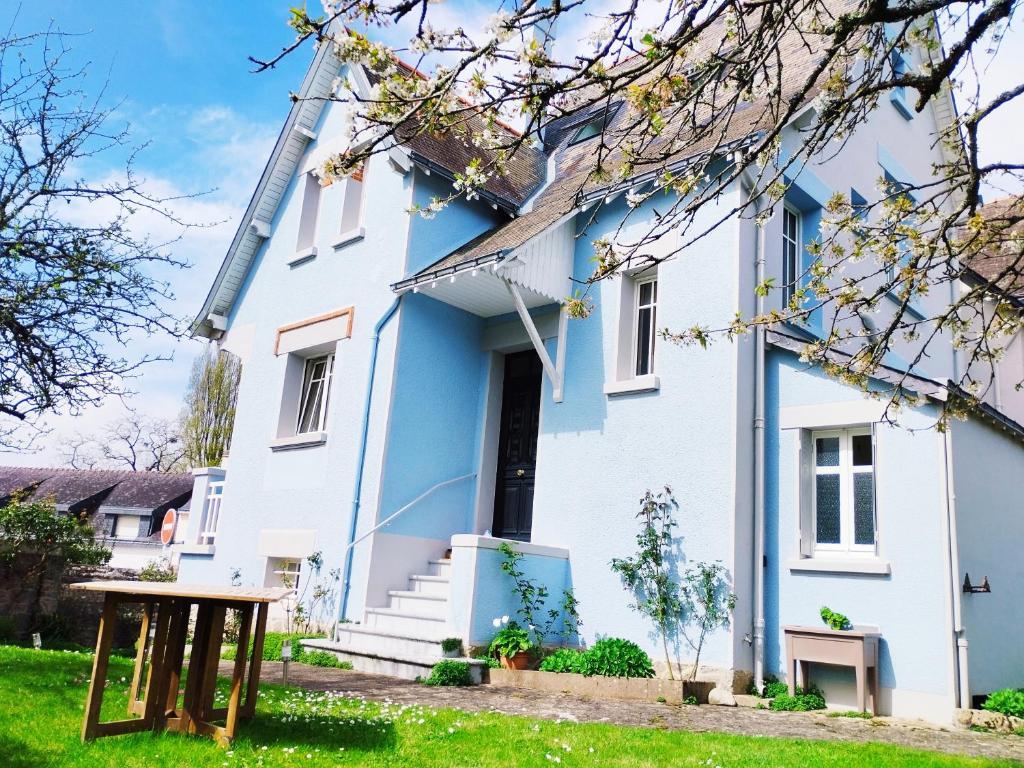 une maison bleue et blanche avec une table devant elle dans l'établissement Maison de Vacances 1930, à Vannes
