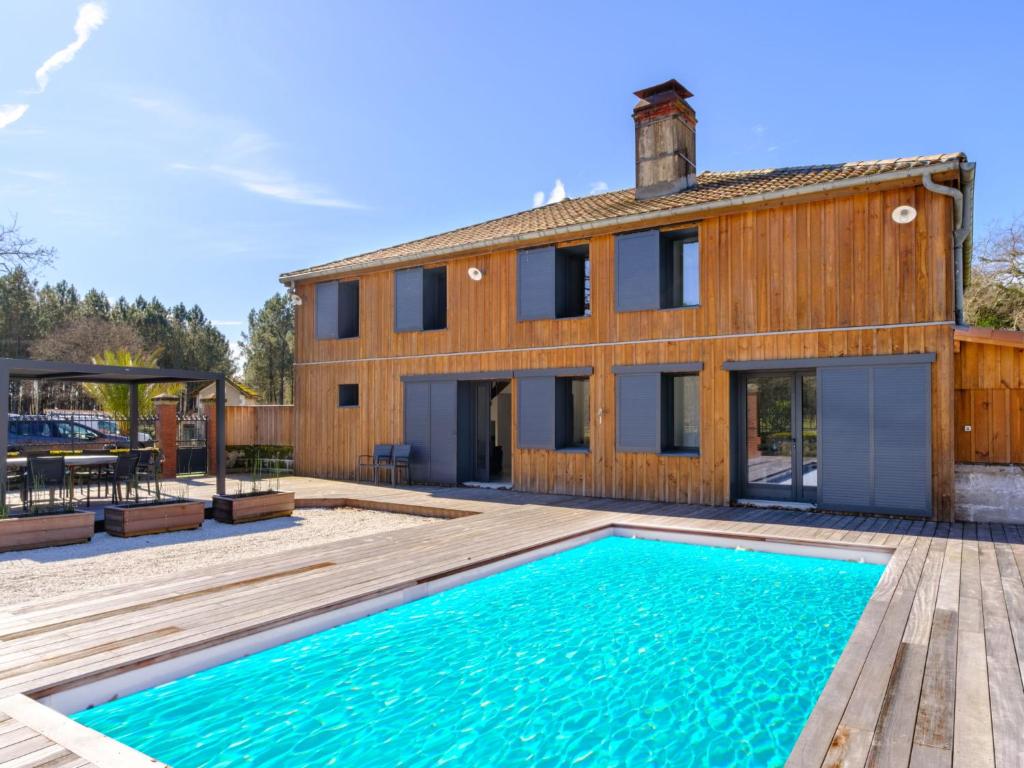une maison avec une piscine devant une maison dans l'établissement Holiday Home Souleyraou by Interhome, à Sainte-Eulalie-en-Born