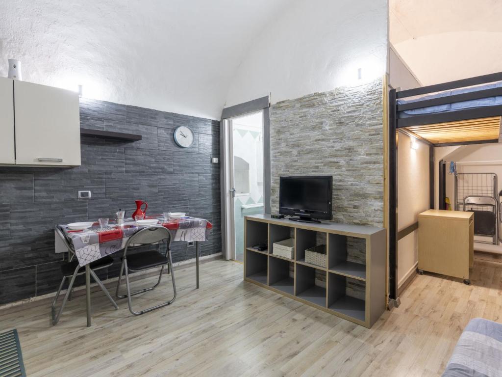 a kitchen with a table and a tv in a room at Holiday Home Kicca by Interhome in Sanremo