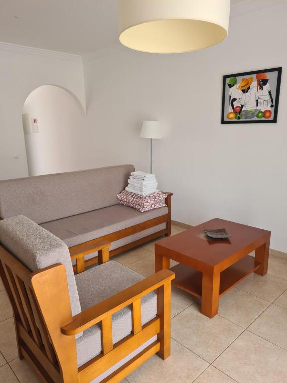 a living room with a couch and a table at APARTAMENTOS CABRITA in Olhos de Água