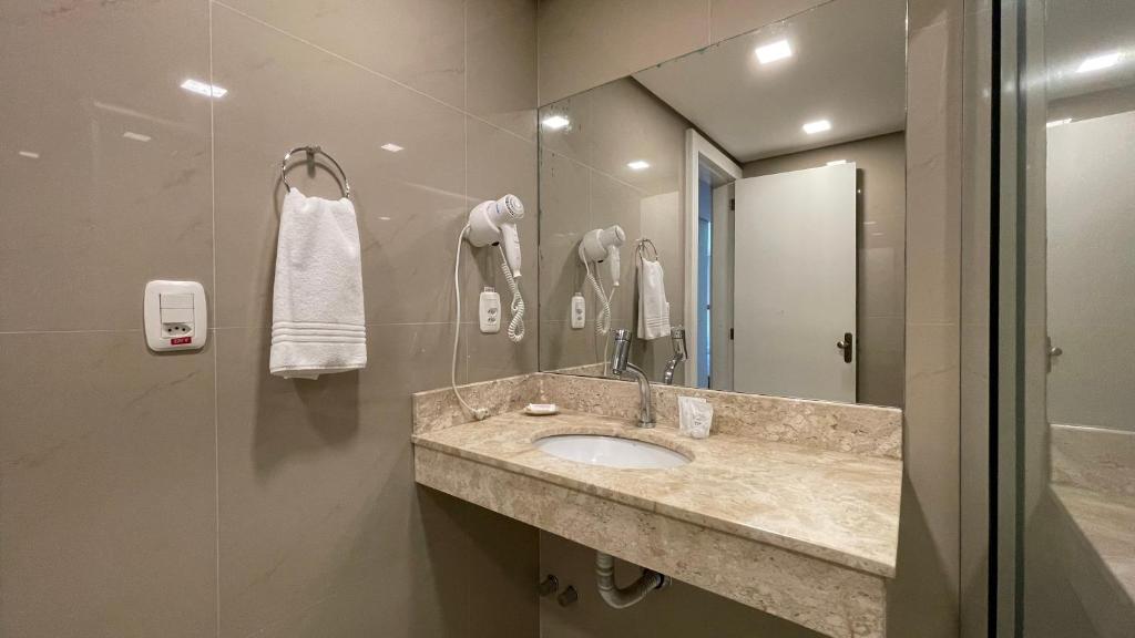 uma casa de banho com um lavatório e um espelho em Pousada Caracol em Canela