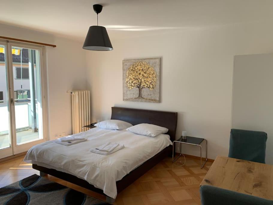 ein Schlafzimmer mit einem Bett, einem Tisch und einer Lampe in der Unterkunft Sunny studio in the city center (Oken1) in Zürich