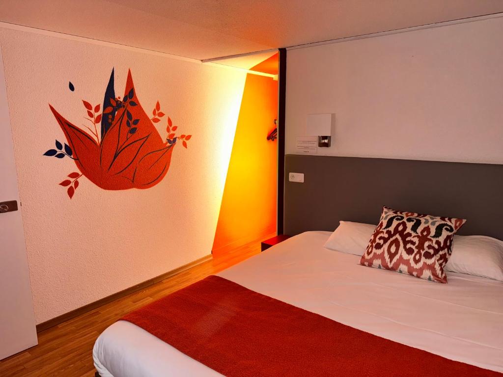 1 dormitorio con 1 cama con una flor en la pared en The Originals City - Hotel Restaurant A Pic en Cherburgo
