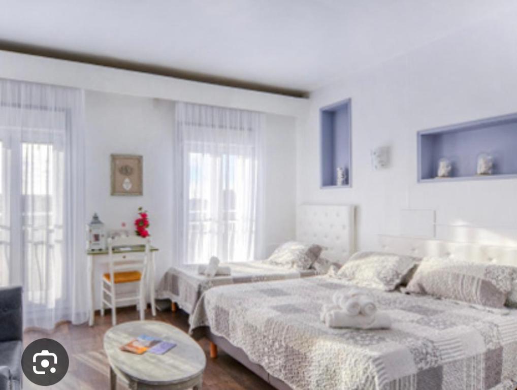 1 dormitorio blanco con 2 camas y mesa en Luberon family, en Apt