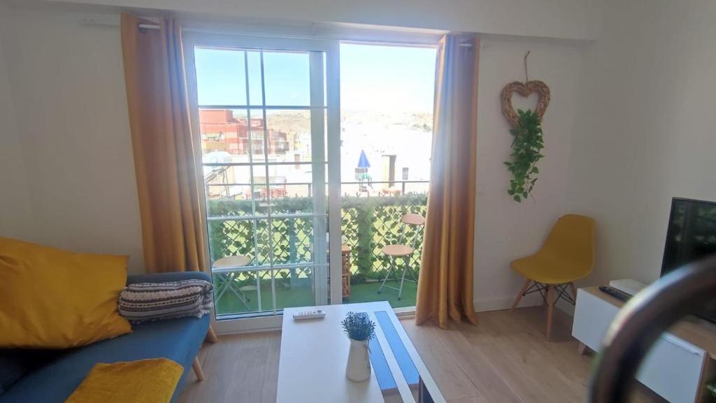 - un salon avec un canapé et une grande fenêtre dans l'établissement La Reina II R&R, à Almería