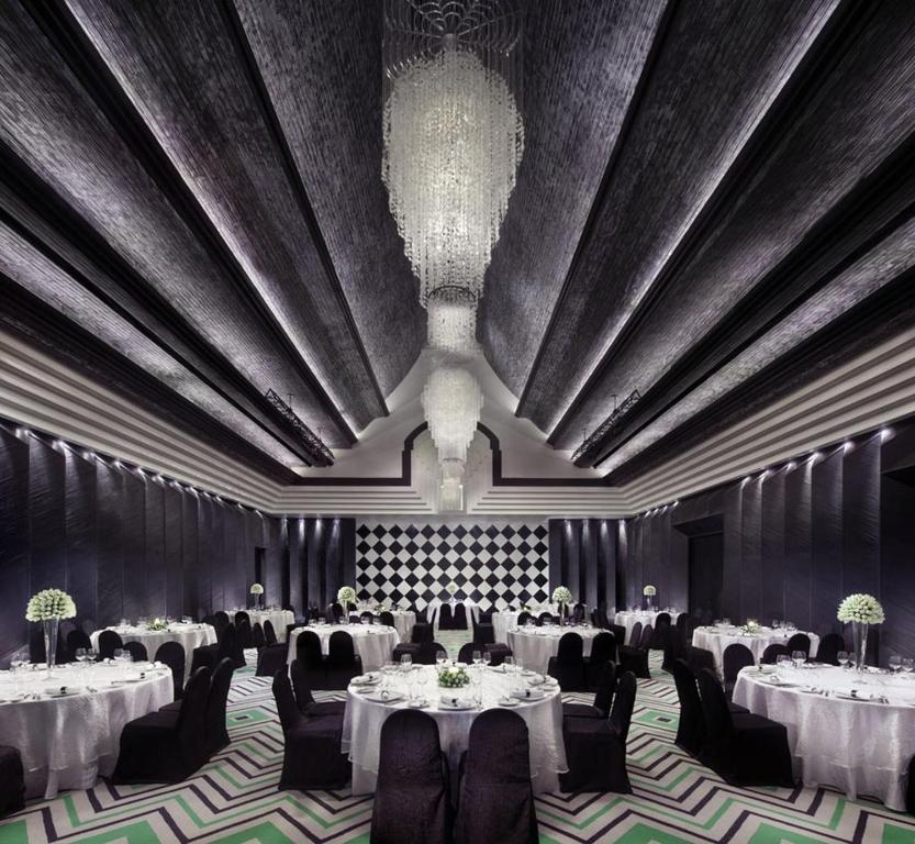 a banquet hall with tables and chairs and a chandelier at InterContinental Danang Sun Peninsula Resort, an IHG Hotel in Danang