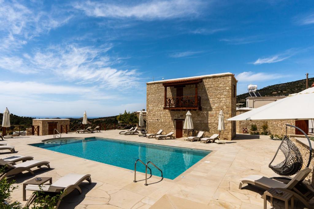 a villa with a swimming pool and patio furniture at Harma Traditional Boutique Suites in Paphos City