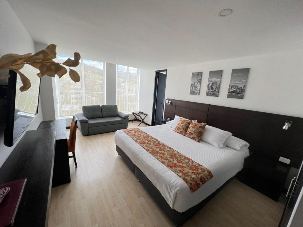 a bedroom with a large bed and a living room at Hotel H53 in Sogamoso