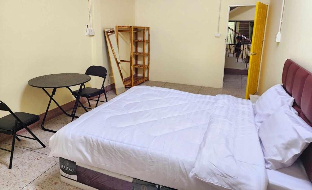um quarto com uma cama, uma mesa e cadeiras em 9 House&homeStay em Hat Yai
