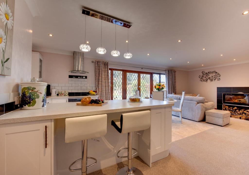 a kitchen with a large island in a living room at Nursery Cottage in Clippesby