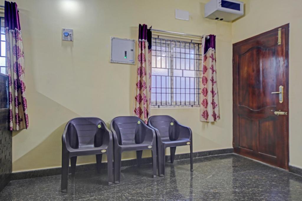 two chairs in a waiting room with a door at Vsv Guest House in Chennai