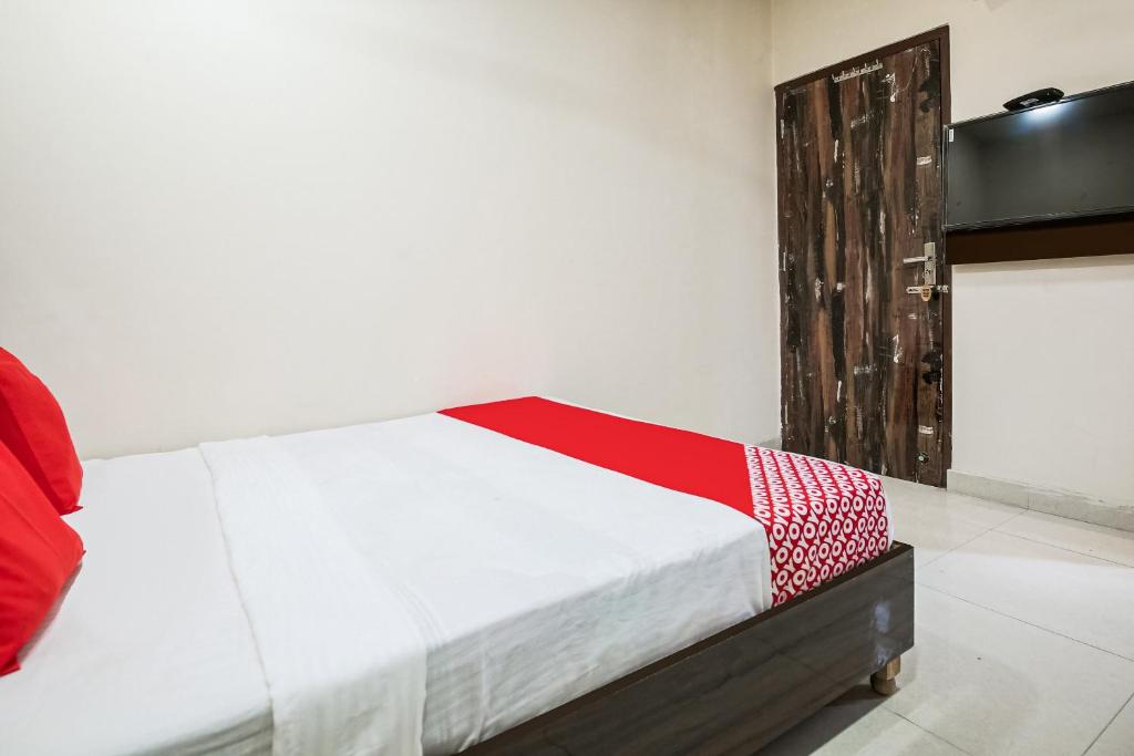 a bedroom with a bed with a red and white blanket at Hotel Sunrise in Ludhiana