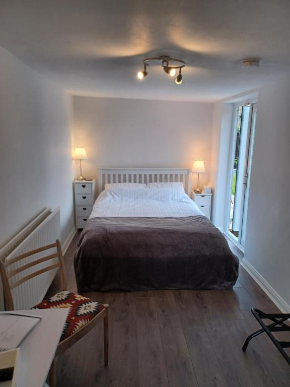 a bedroom with a bed and two tables and two lamps at Eskdale Durham DH1 in Durham
