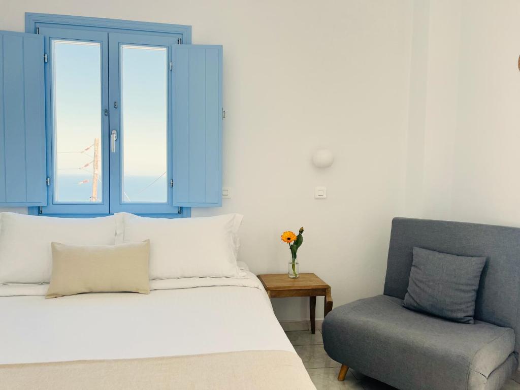 1 dormitorio con 1 cama, armario azul y silla en Villa Fotini, en Firostefani
