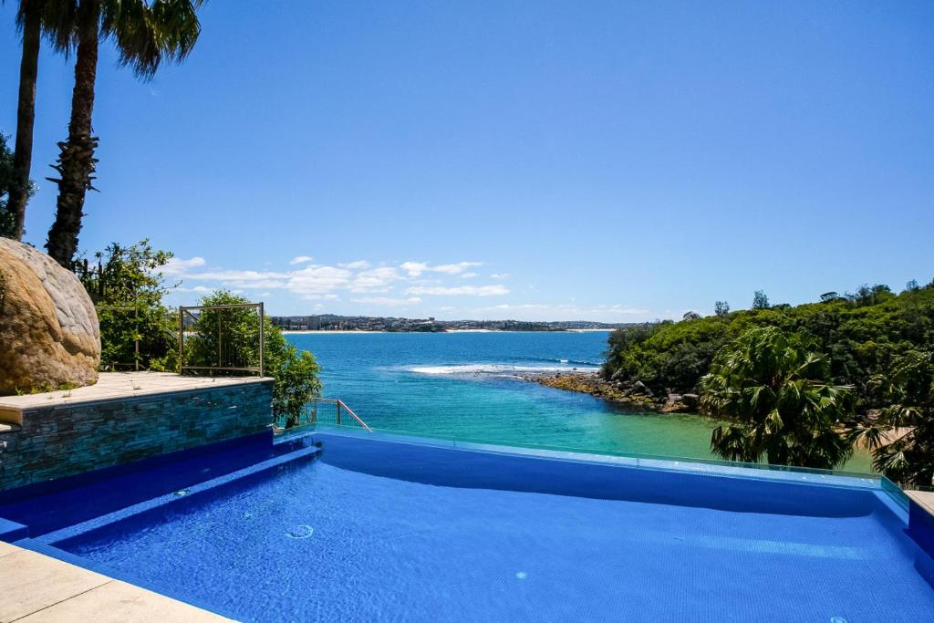 a swimming pool with a view of a body of water at Bower House in Sydney