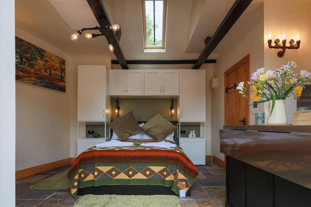 a bedroom with a bed and a vase of flowers at Cosy countryside retreat, Weiser in Buckinghamshire