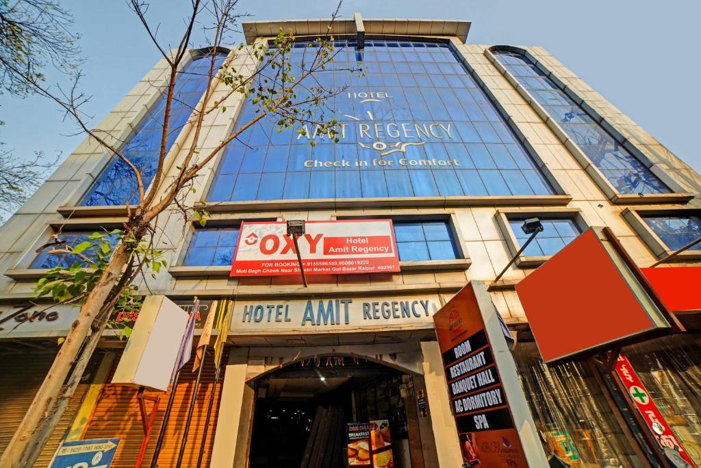 een gebouw met een bord ervoor bij Capital O Convivial Hotel Amit Regency in Raipur