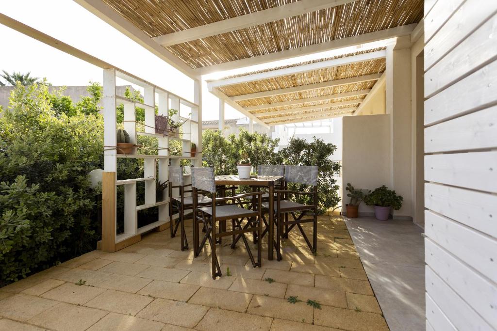 a patio with a table and chairs under a pergola at Gl holiday home in Marsala