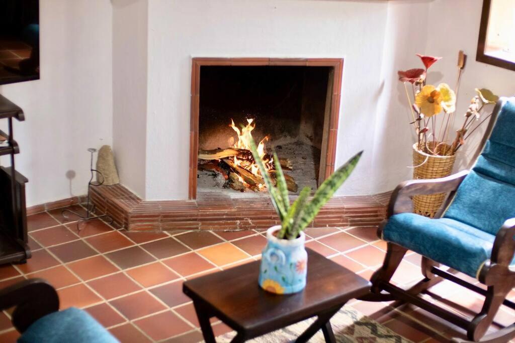 a living room with a fire in the fireplace at Hermosa Casa de Campo los Montes en Zapatoca in Zapatoca