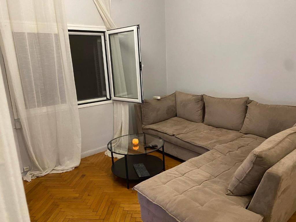 a living room with a couch and a glass table at Johnny house in Athens