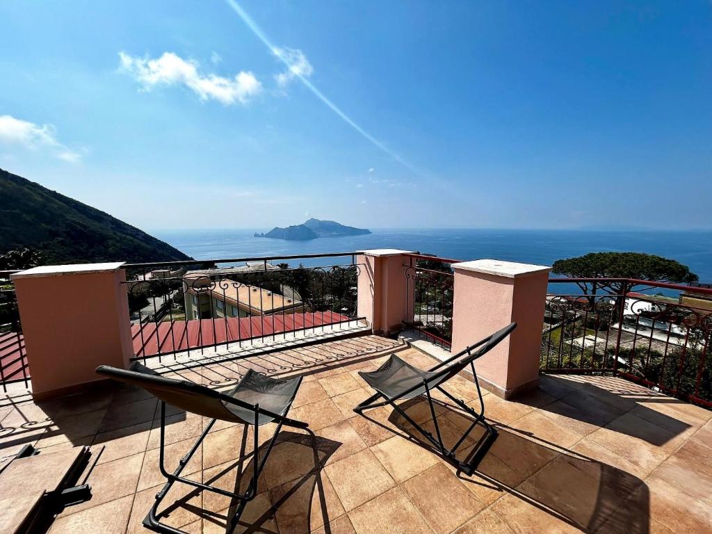 2 stoelen op een balkon met uitzicht op de oceaan bij Apartment Tramonto su Capri by Interhome in Massa Lubrense