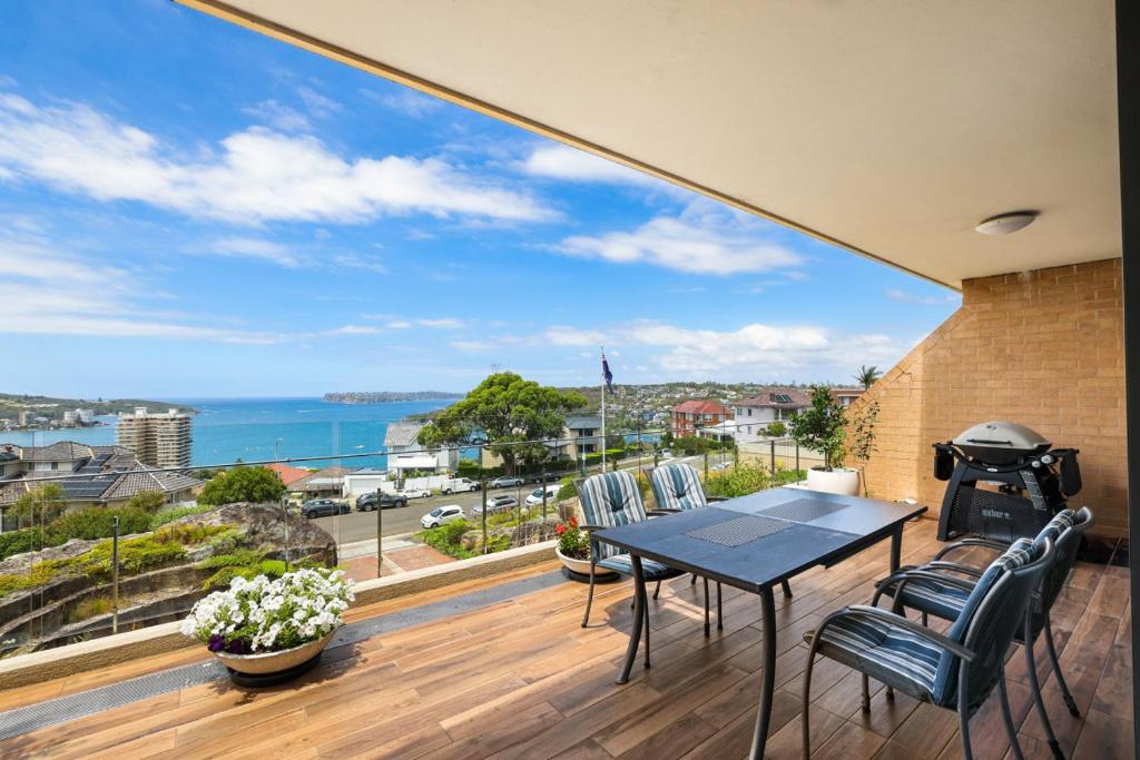 a balcony with a table and chairs and a view of the ocean at Tarquin - Harbour Views in Sydney