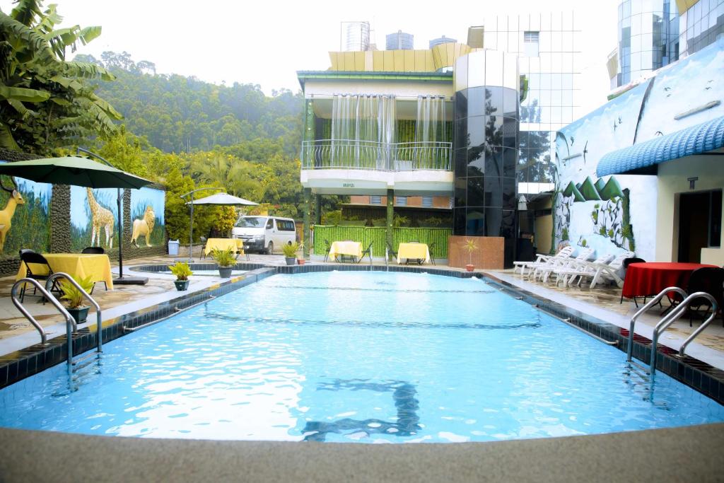 a large swimming pool with chairs and a building at Western Mountain Hotel in Rubavu