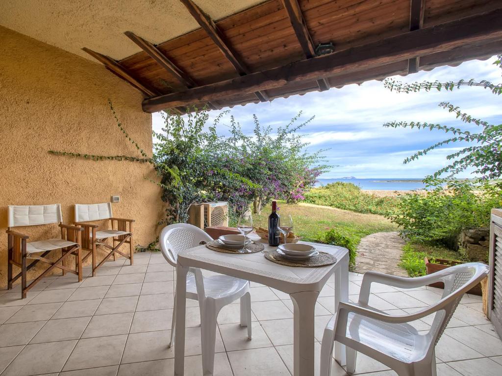 a white table and chairs on a patio at Apartment 0-5-F - Marineledda by Interhome in Golfo Aranci