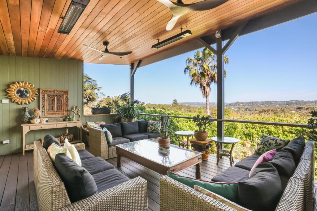 an outdoor patio with couches and a table at Warriewood Beach Pad in Mona Vale