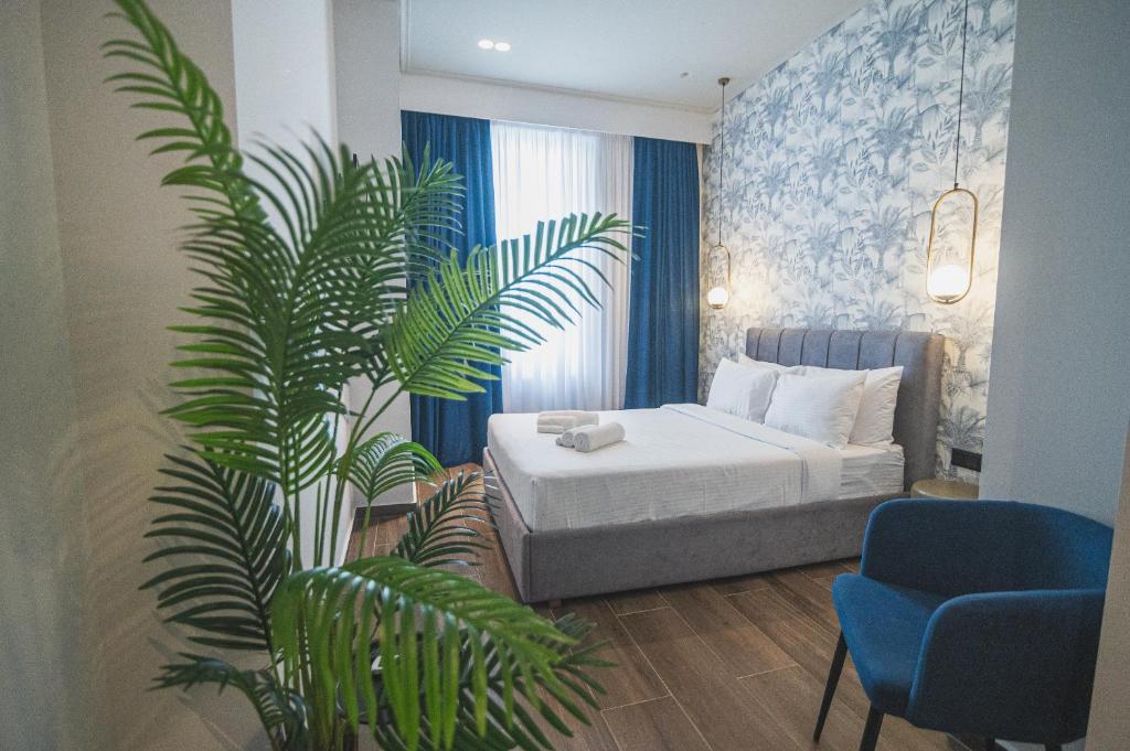 - une chambre avec un lit et une plante en pot dans l'établissement Downtown Suites by Athens Tower Hotel, à Athènes