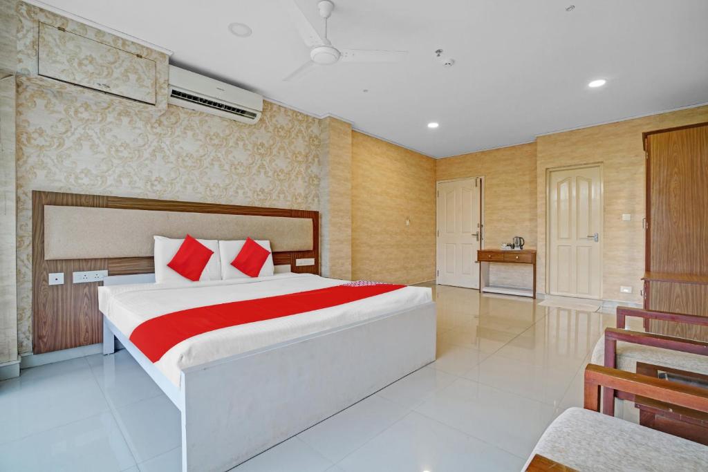 1 dormitorio con 1 cama grande con almohadas rojas en Capital O Vazhakkala Residency en Kakkanad