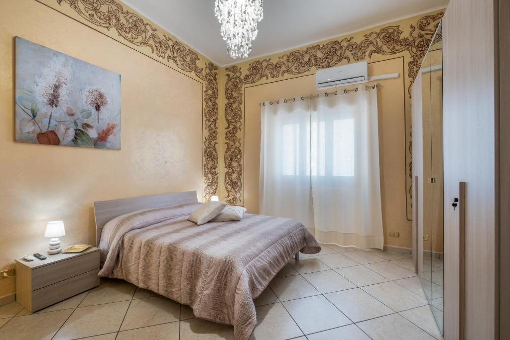 1 dormitorio con cama y lámpara de araña en Relax House, en Squinzano