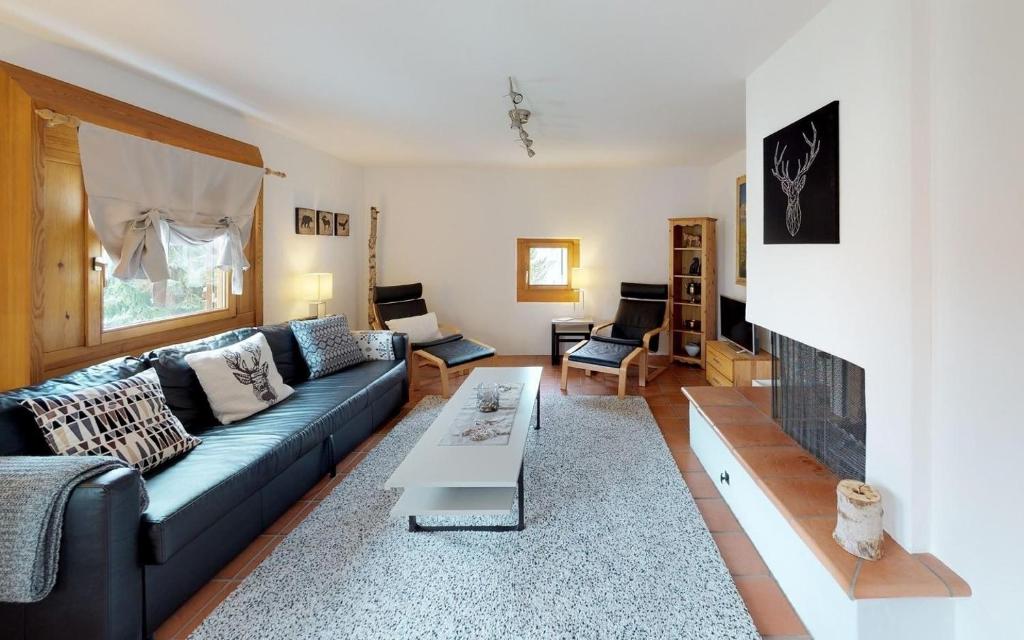 ein Wohnzimmer mit einem blauen Sofa und einem Kamin in der Unterkunft Maurus A3 in St. Moritz
