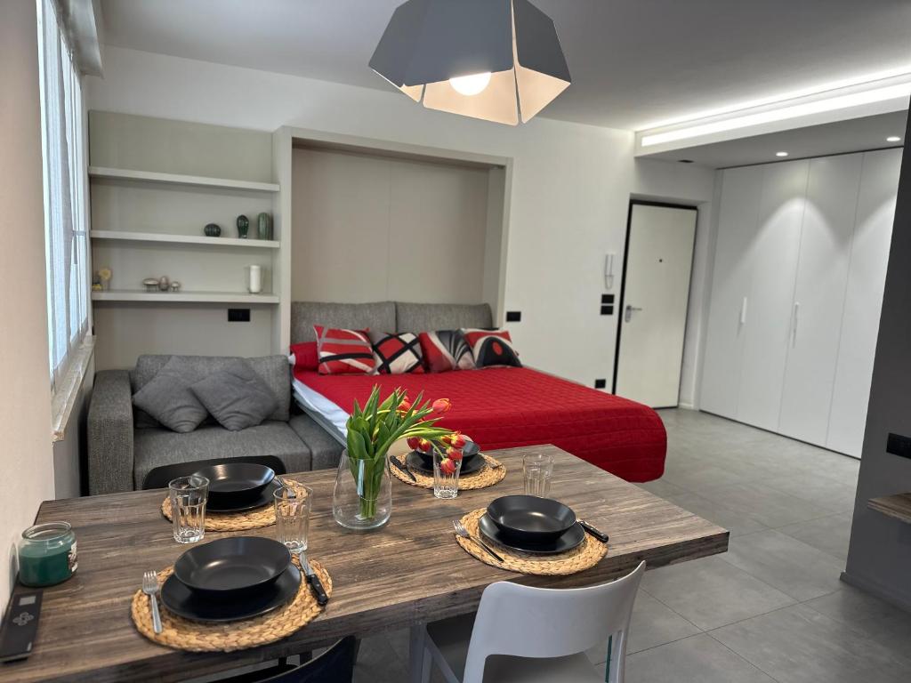 a living room with a table and a bed at Modern apartment on the beach in Nago-Torbole