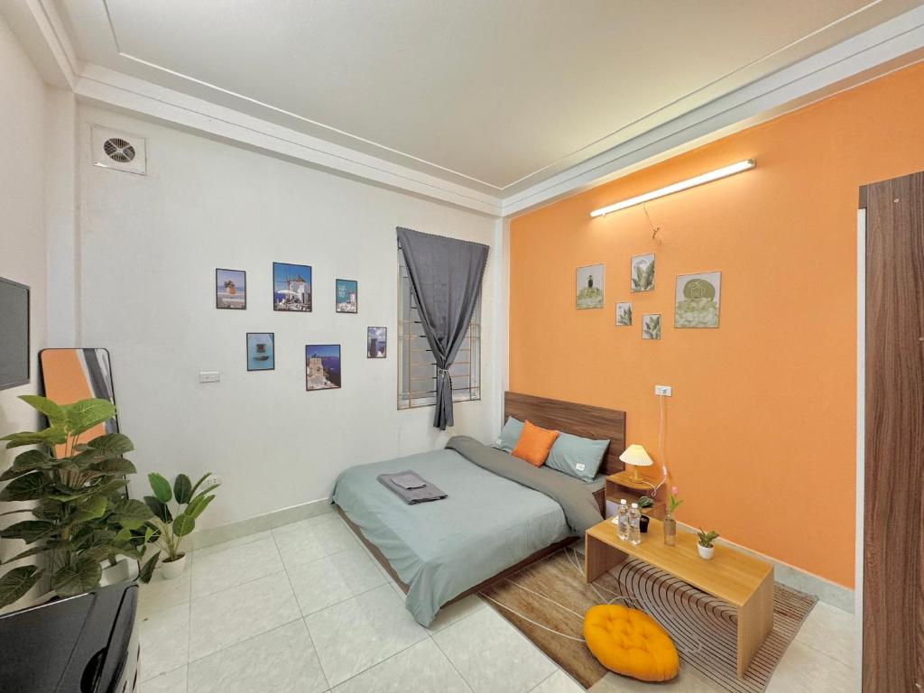 1 dormitorio con 1 cama en una habitación con paredes de color naranja en Sweet home * Center * Cozy, en Hanói