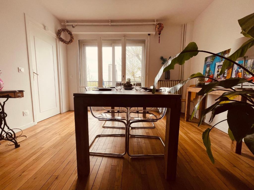 a dining room with a table and a plant at La brocante sur la seine -309 in Rouen