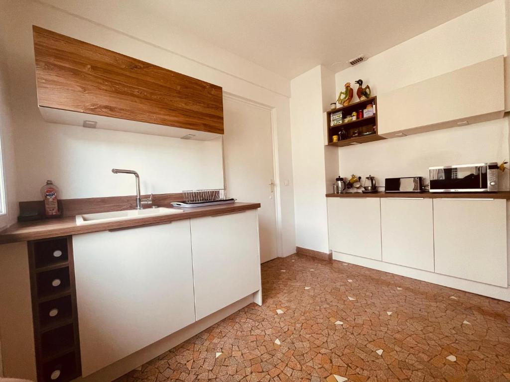 a kitchen with white cabinets and a sink at La brocante sur la seine -309 in Rouen